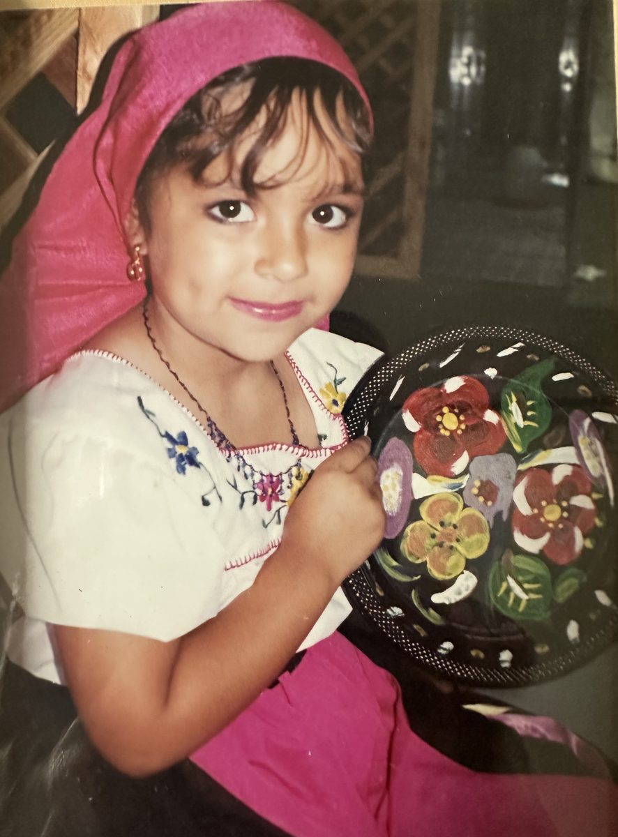 Young dancer in traditional embroidered dress with hand-painted gourd