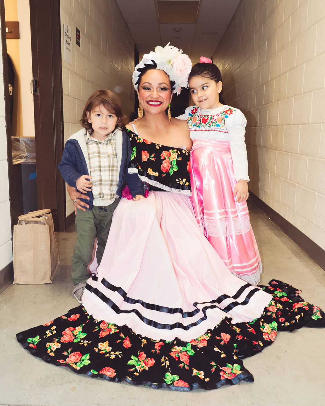 Ms. Itzel Garcia-Alarcon, founder of Garcia Folklorico Studio, in folklorico dress with two young dancers